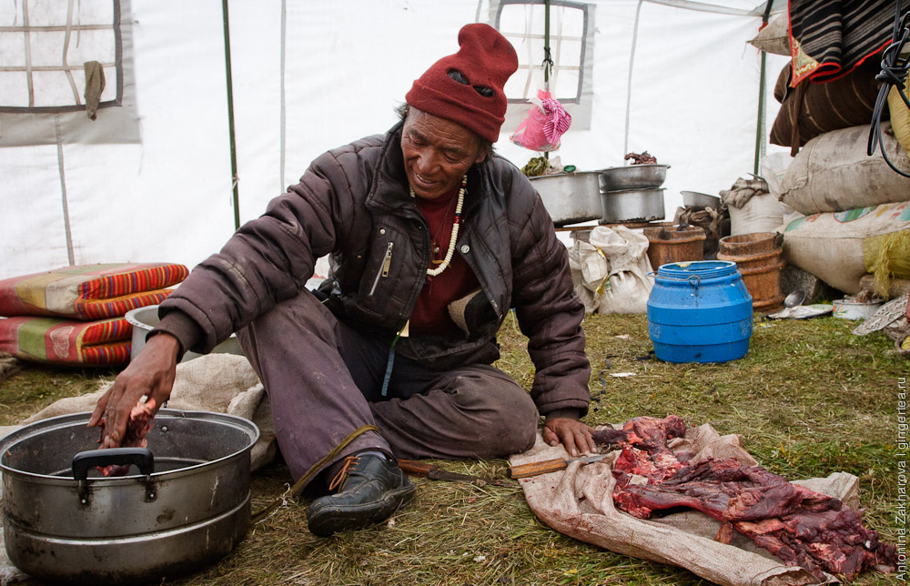 тибетец режет мясо в палатке