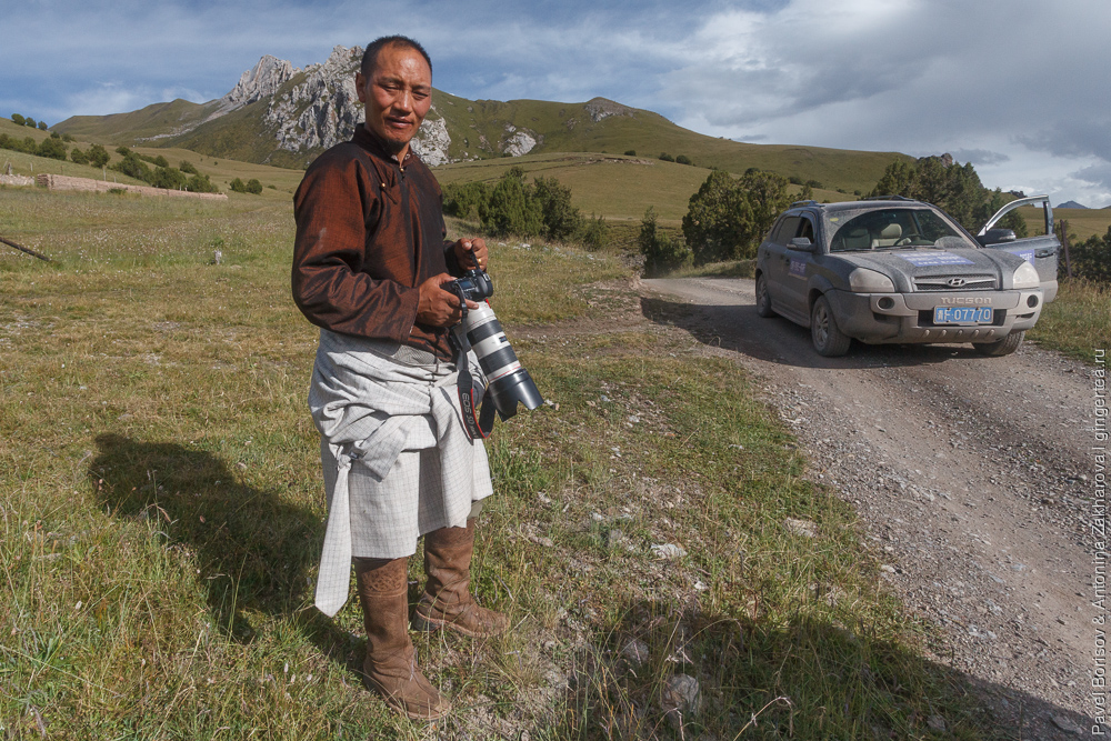 тибетец с фотоаппартом Canon и длиннофокусным объективом