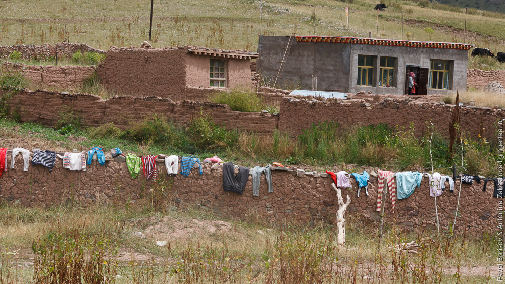 белье сушится на заборе тибетского дома в провинции Цинхай
