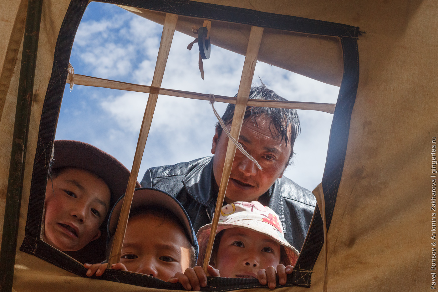 тибетцы заглядывают через окно палатки