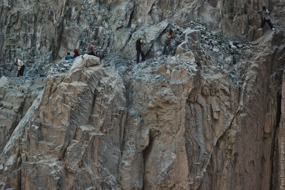 индийские рабочие ломами откалывают куски скалы на строящейся дороге из Леха в Падум