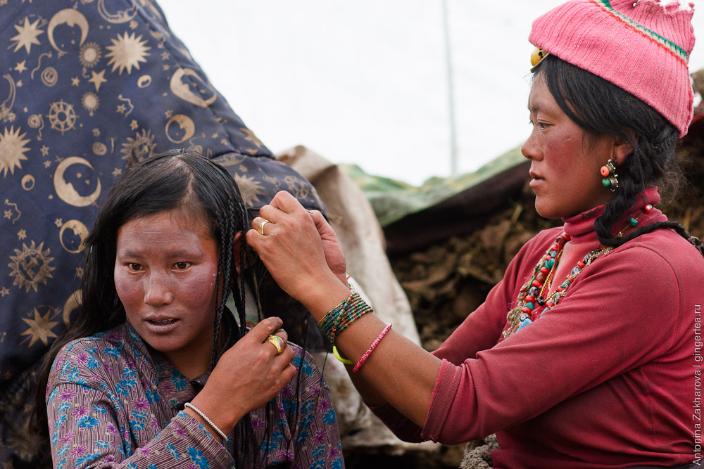 тибетские девушки заплетают друг другу косы в Китае в провинции Цинхай